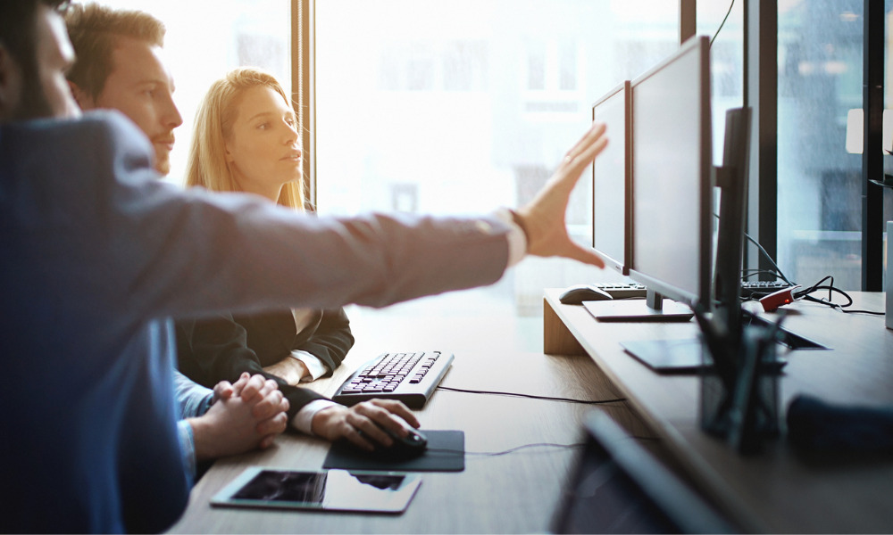 Mão apontando para tela de computador