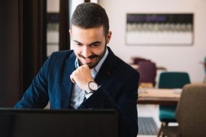 Advogado em um escritório mexendo no notebook, representando o papel software jurídico.