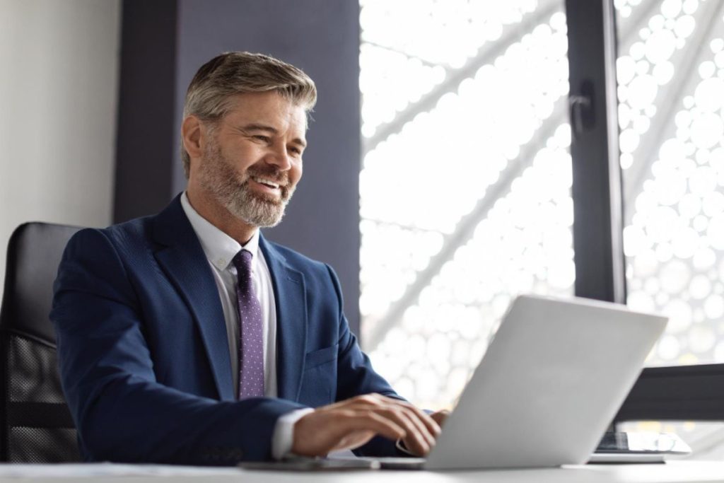 Advogado mexendo no computador em um escritório, representando uma plataforma jurídica.