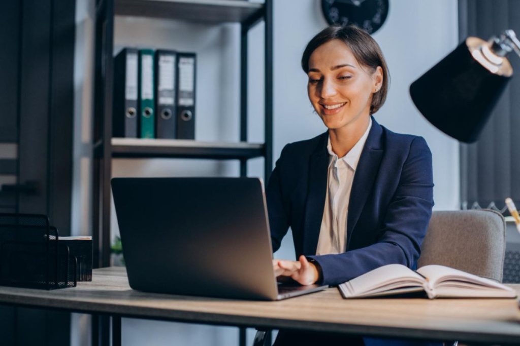Advogada utilizando notebook em um escritório moderno, representando uma plataforma para advogados.