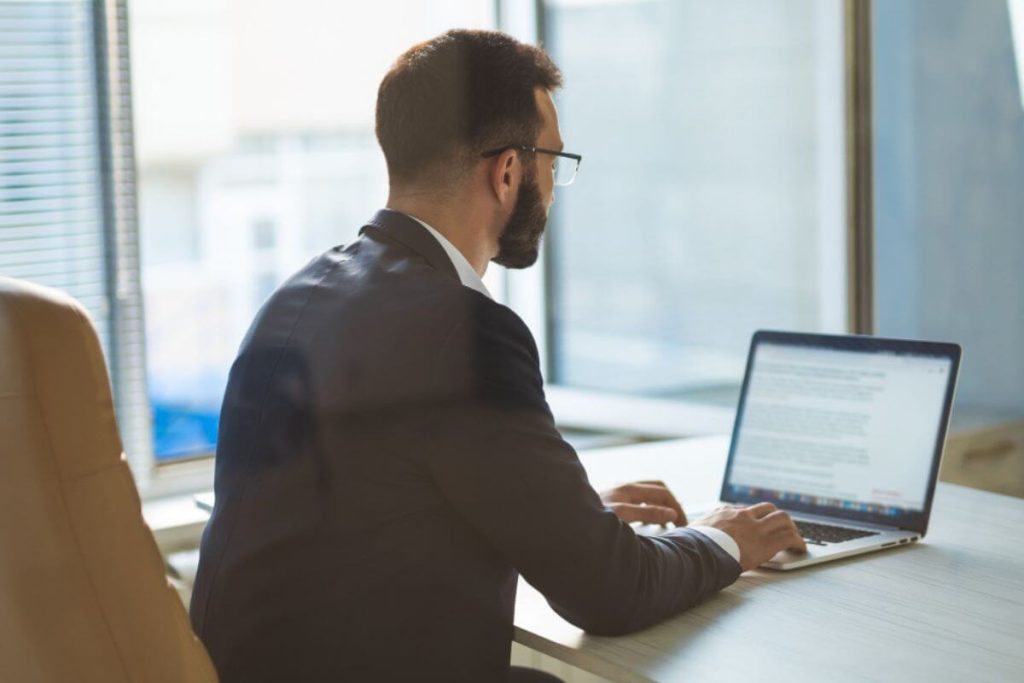 Advogado digitando um documento no notebook, representando qual melhor software jurídico.
