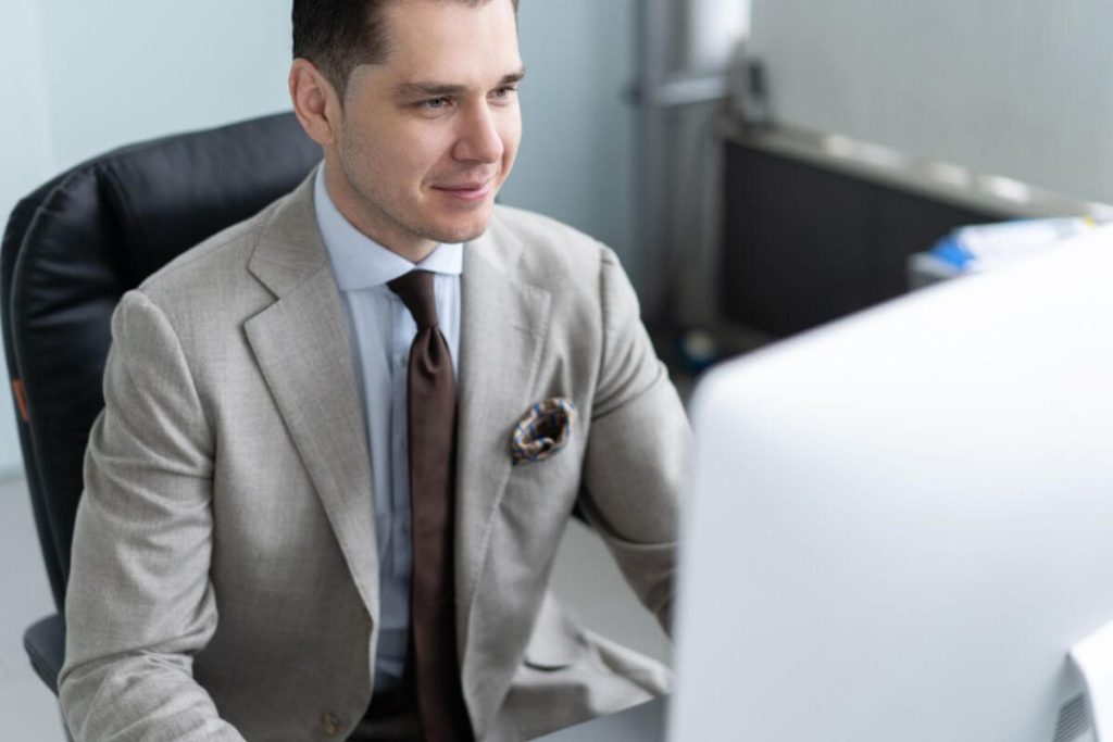 Advogado concentrado mexendo no computador, representando software jurídico para empresas.