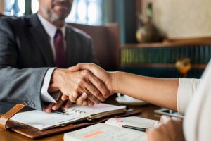 Advogado apertando a mão de uma cliente, representando como captar clientes na advocacia.