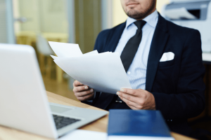 Imagem de advogado analisando documentos, com um notebook à frente, representando um artigo do GOJUR sobre automação de documentos jurídicos.